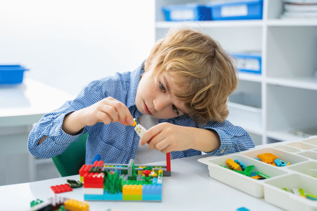 Дете строи с LEGO тухлички. 