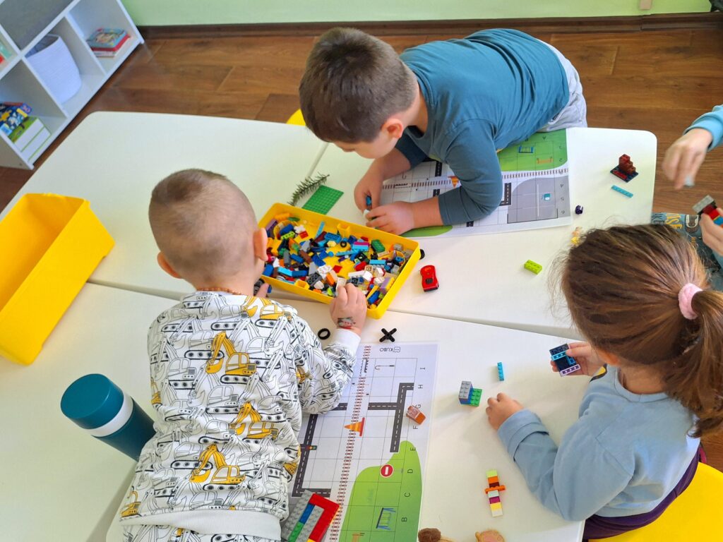 Деца играят с LEGO в курс по роботика